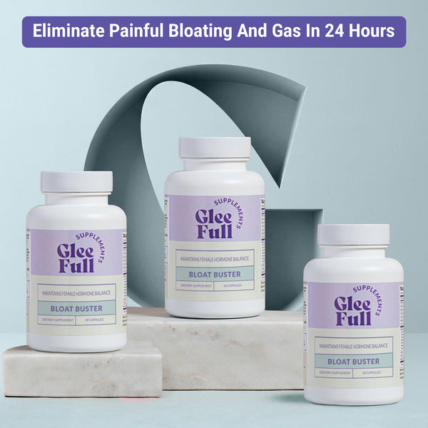 Three white GleeFull Bloat Buster bottles on marble blocks against a light blue-grey background. Purple banner reads: 'Eliminate Painful Bloating And Gas In 24 Hours'. Labels read 'Maintains Female Hormone Balance, Bloat Buster, 60 Capsules'.