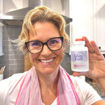 Smiling woman holding a bottle of GleeFull Over 30 Hormone Support