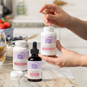 GleeFull Carb Blocker, Meno Morning Fat Burner (amber dropper), and Meno-Shred Fat Burner bottles on a marble countertop in a kitchen setting.