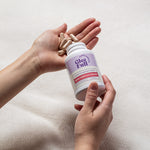 Person holding a Gleefull Meno-Shred Fat Burner with beige capsules on a light background