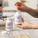 GleeFull Over 30 Hormone Support and Meno Belly Flusher bottles on a marble countertop in a kitchen setting.